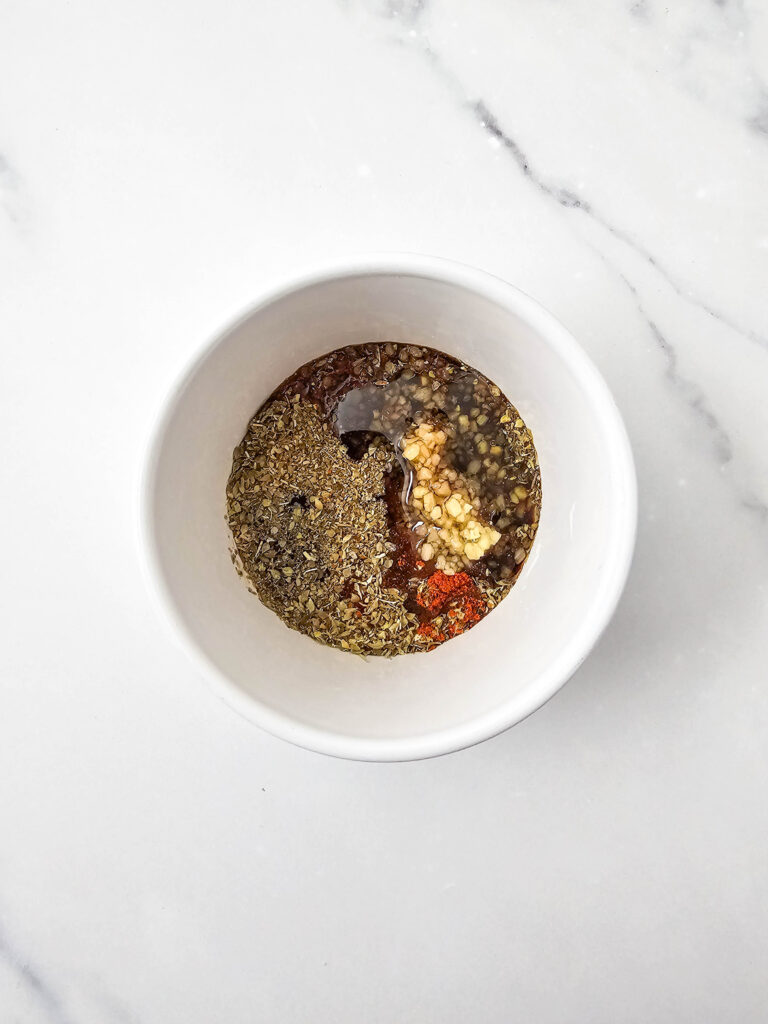 Seasonings, garlic, and liquids in a bowl before stirring.